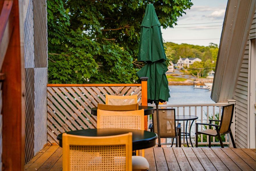 Private deck with outdoor seating, umbrella, and views of Boothbay Harbor